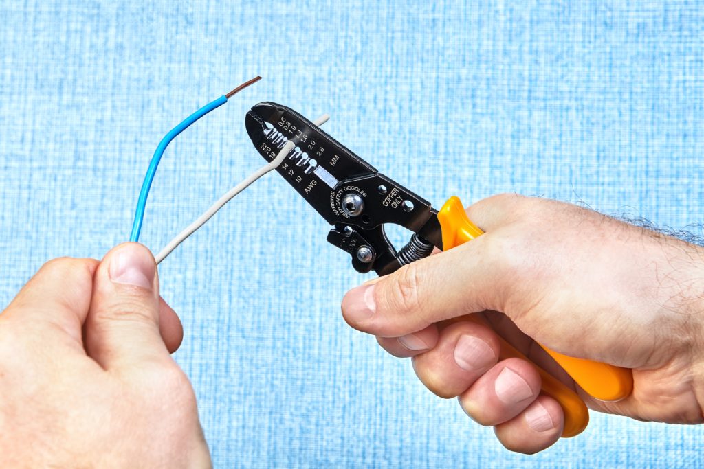 Electrician using manual wire stripper-how to use wire strippers